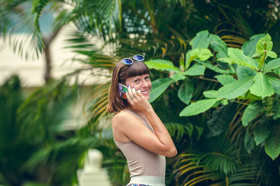 A traveler smiling while using her phone abroad